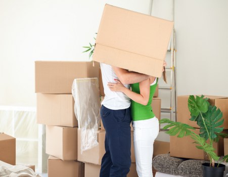 Professional movers transporting furniture through a Greenwich street
